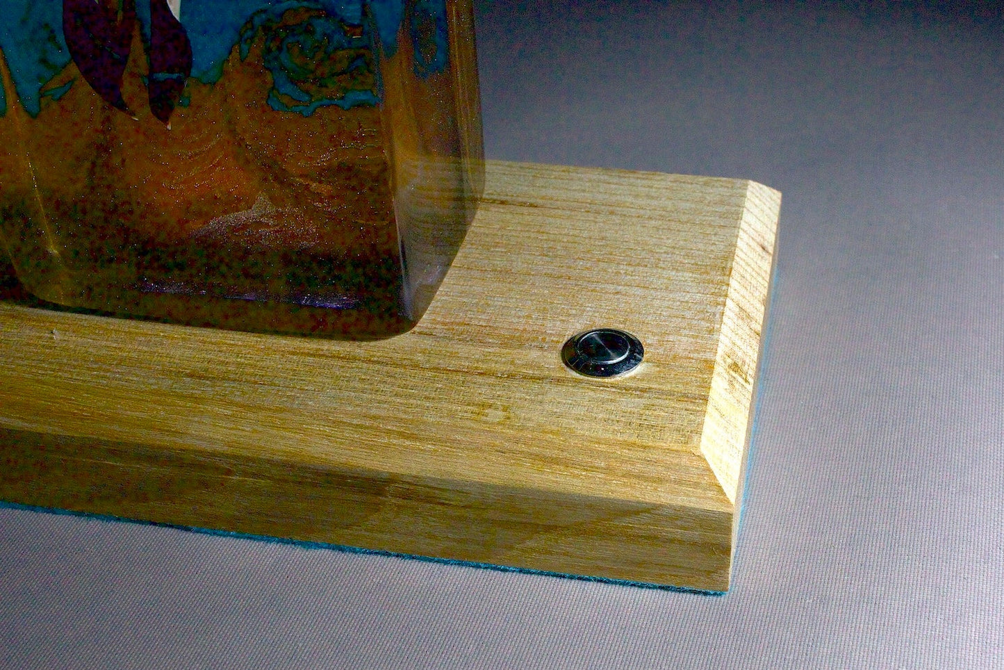 Bird skull in resin against a turbulent blue background with a timber base